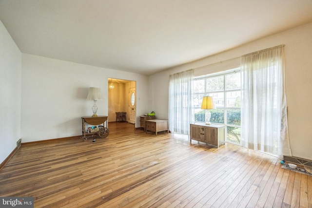living area with wood-type flooring and baseboards