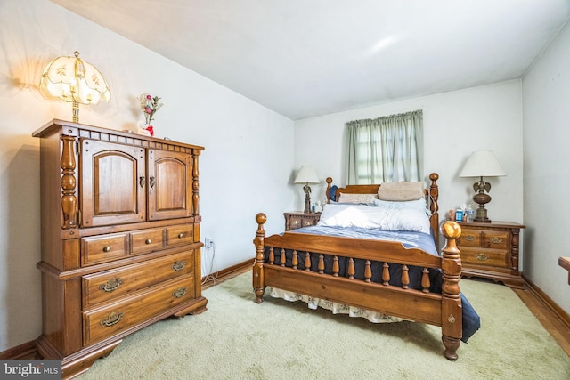 bedroom with baseboards and light carpet