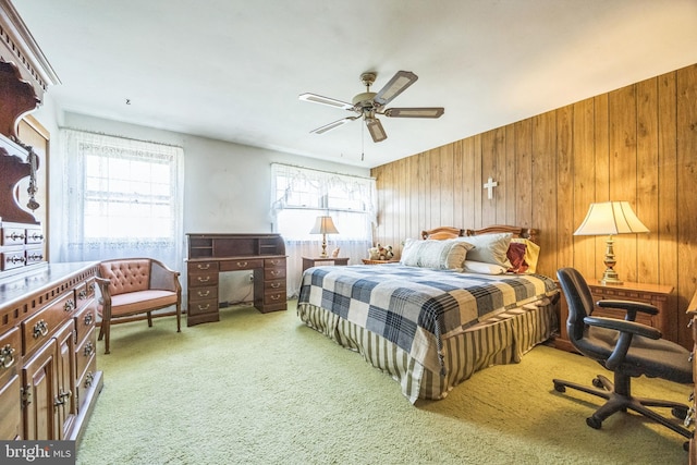 bedroom with multiple windows, wood walls, carpet flooring, and ceiling fan