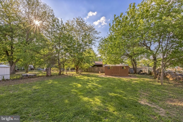 view of yard featuring a storage shed and an outbuilding