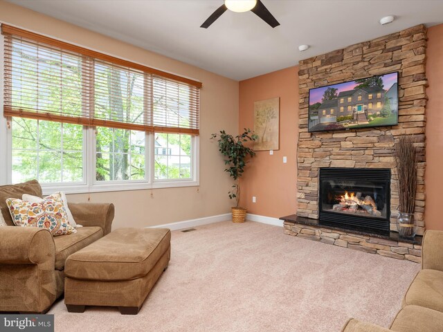 3325 Cedar Dr, Edgewater, MD 21037 - living area featuring carpet flooring, ceiling fan, a stone fireplace, baseboards, and visible vents