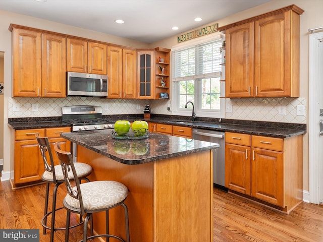 3325 Cedar Dr, Edgewater, MD 21037 - kitchen with stainless steel appliances, a breakfast bar, a sink, and light wood finished floors