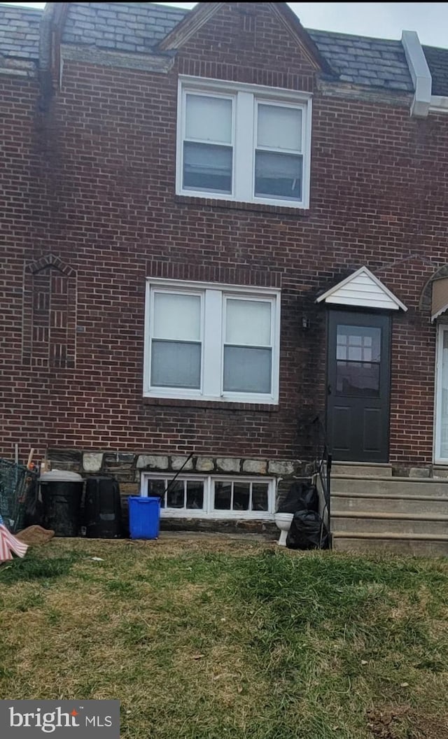 view of front of home featuring a front lawn and brick siding