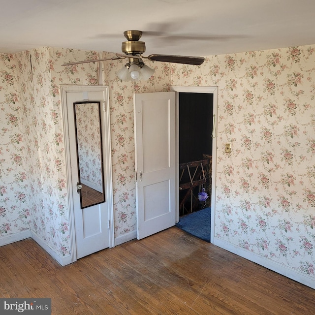 empty room featuring wood finished floors, ceiling fan, and baseboards