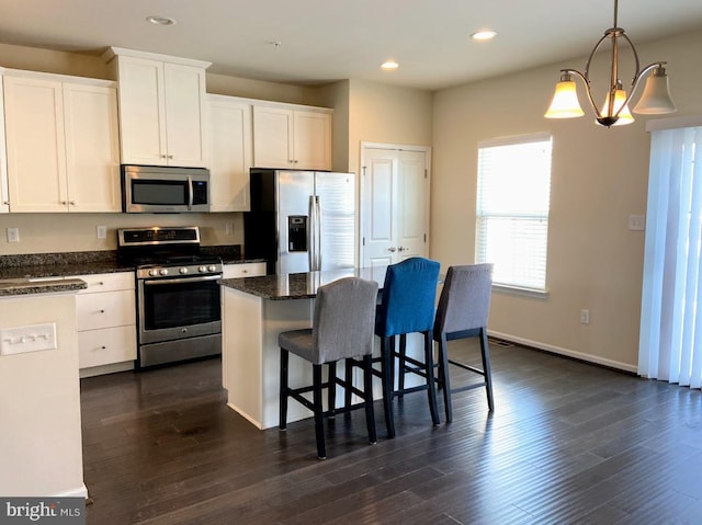 kitchen with a breakfast bar area, recessed lighting, white cabinets, and appliances with stainless steel finishes