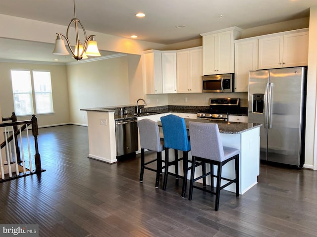 kitchen with white cabinets, dark wood-style flooring, appliances with stainless steel finishes, recessed lighting, and a peninsula