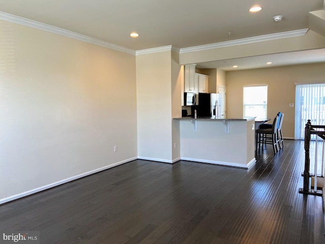 living area with crown molding, recessed lighting, dark wood-style flooring, and baseboards