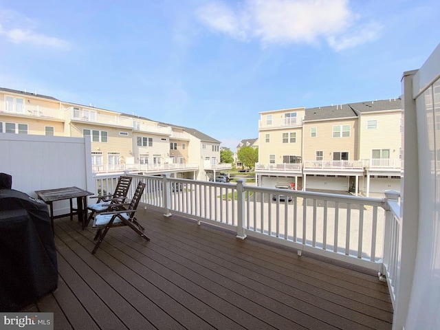 wooden deck with a residential view and a grill
