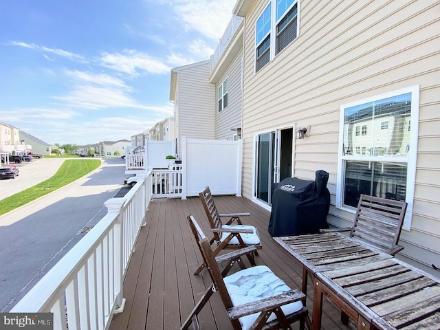 wooden terrace with a residential view and area for grilling