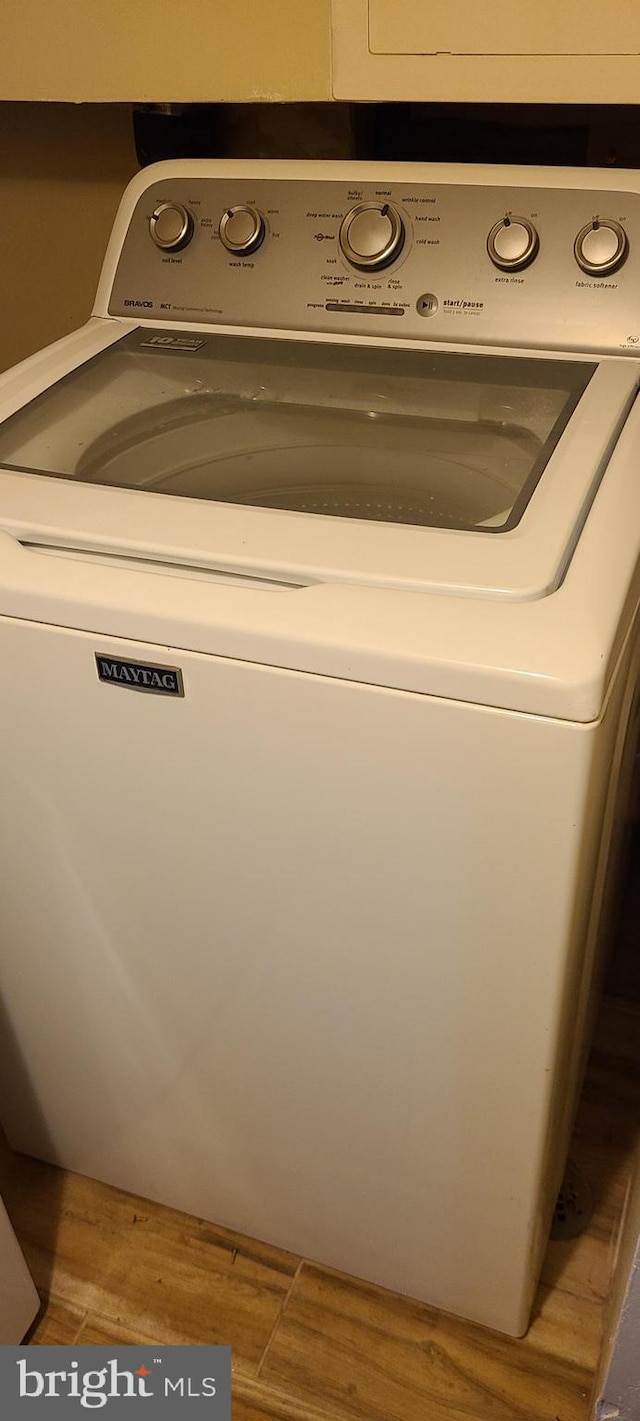 laundry area with wood finished floors, laundry area, and washer / clothes dryer