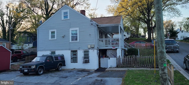 view of front facade with a chimney and fence