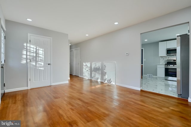 interior space with light wood-type flooring, baseboards, recessed lighting, and visible vents