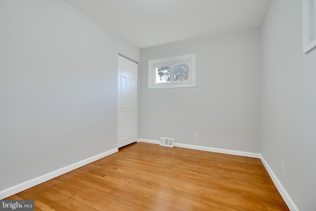 spare room featuring baseboards, light wood finished floors, and visible vents