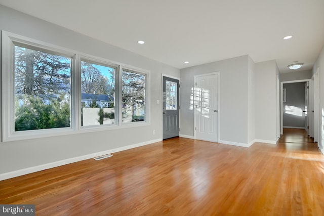 foyer entrance featuring baseboards, light wood-style floors, and visible vents
