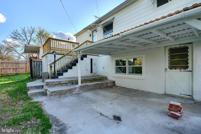 view of patio with fence and stairs