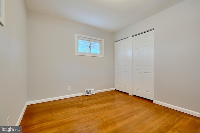 unfurnished bedroom featuring baseboards, visible vents, and light wood-style flooring
