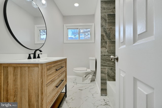 full bath with vanity, marble finish floor, a tub, baseboards, and toilet