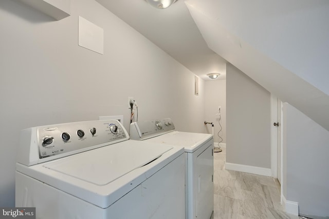 washroom featuring baseboards, marble finish floor, washer and dryer, and laundry area