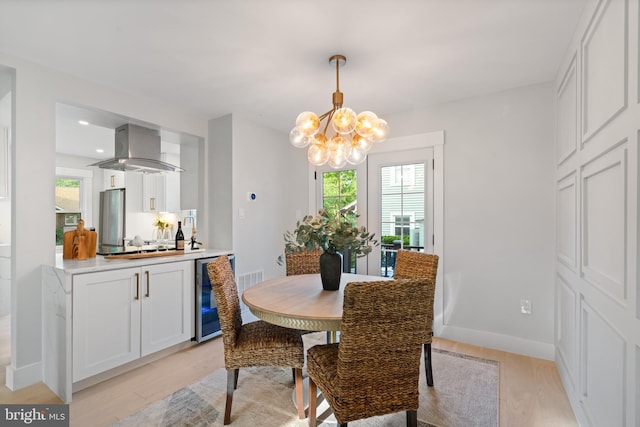 3838 13th St N, Arlington, VA 22201 - dining space featuring beverage cooler, a chandelier, light wood-style flooring, and baseboards