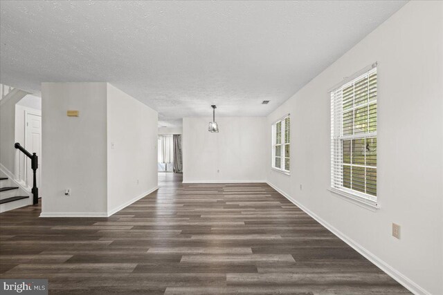 5127 Beaugregory Ct, Waldorf, MD 20603 - unfurnished living room featuring baseboards, a textured ceiling, stairs, and dark wood-style flooring