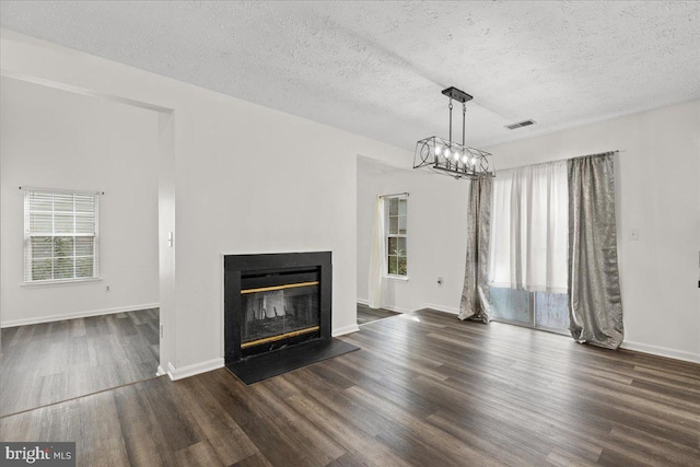5127 Beaugregory Ct, Waldorf, MD 20603 - unfurnished living room featuring a glass covered fireplace, visible vents, baseboards, a textured ceiling, and wood finished floors