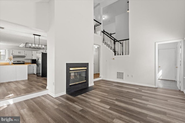 5127 Beaugregory Ct, Waldorf, MD 20603 - unfurnished living room featuring dark wood finished floors, visible vents, baseboards, and a towering ceiling