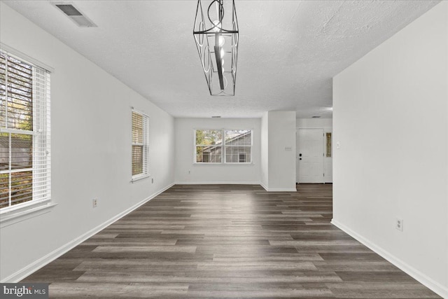 5127 Beaugregory Ct, Waldorf, MD 20603 - unfurnished living room featuring dark wood-style floors, a notable chandelier, visible vents, baseboards, and a textured ceiling
