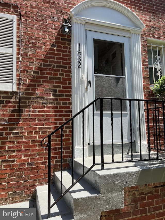 view of exterior entry featuring brick siding