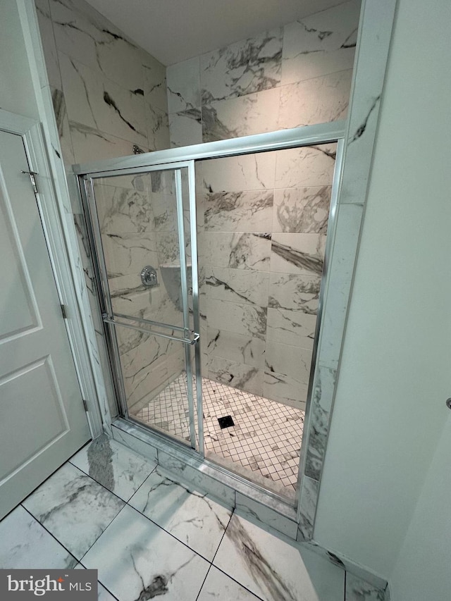 full bathroom with marble finish floor and a stall shower