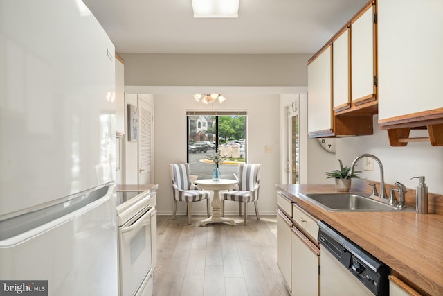 9552 Cannoneer Ct Unit 204, Manassas, VA 20110 - kitchen with white appliances, a sink, light wood finished floors, baseboards, and a chandelier