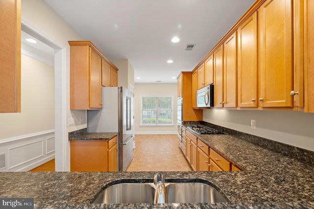 20449 Rosses Point Ct, Ashburn, VA 20147 - kitchen featuring appliances with stainless steel finishes, dark stone counters, recessed lighting, and wainscoting