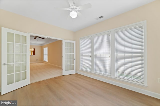 20449 Rosses Point Ct, Ashburn, VA 20147 - empty room featuring wood finished floors, a chandelier, ceiling fan, crown molding, and french doors