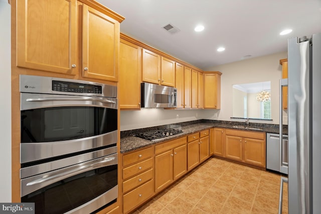 20449 Rosses Point Ct, Ashburn, VA 20147 - kitchen with appliances with stainless steel finishes, dark stone counters, recessed lighting, and a chandelier