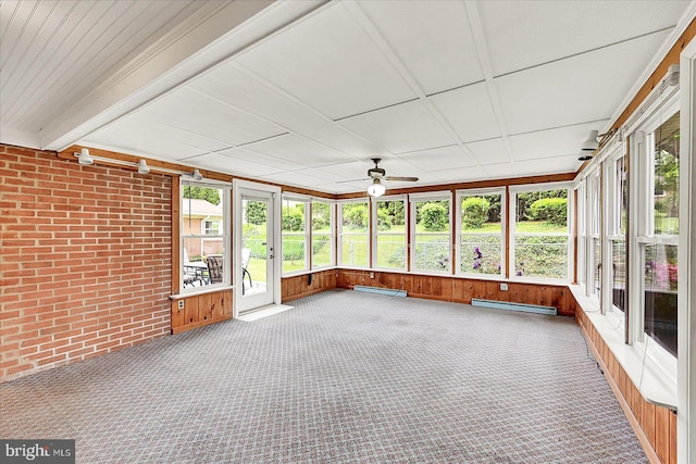 unfurnished sunroom with plenty of natural light, a ceiling fan, and a baseboard heating unit
