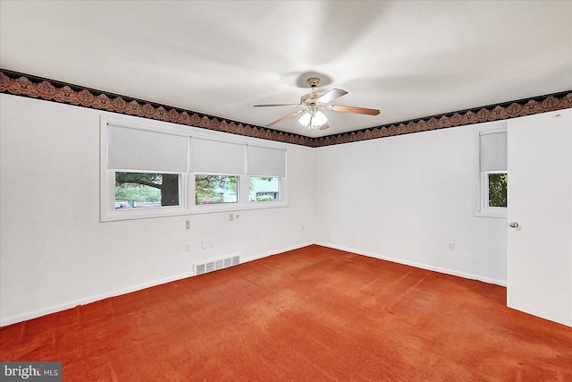 carpeted empty room with baseboards, ceiling fan, and visible vents