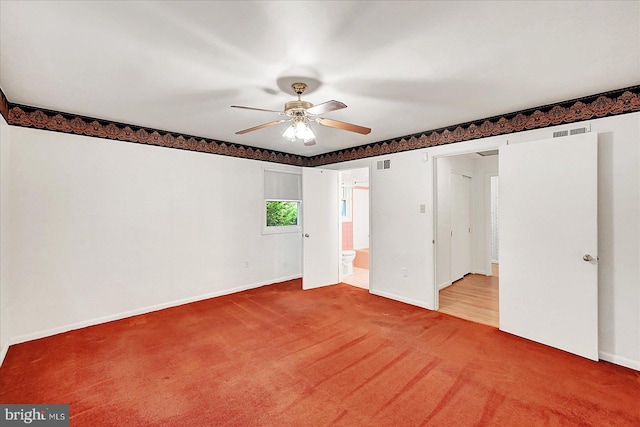 carpeted empty room with baseboards, ceiling fan, and visible vents