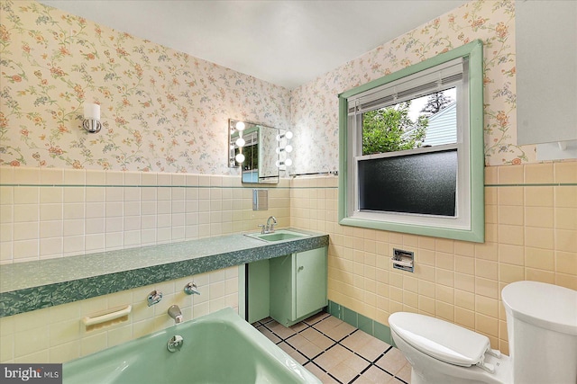 bathroom with a sink, tile walls, a bath, and tile patterned floors