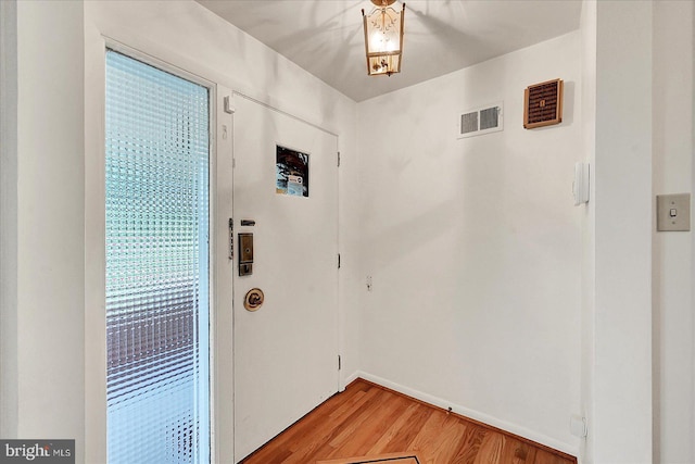 interior space featuring light wood-type flooring, visible vents, and baseboards