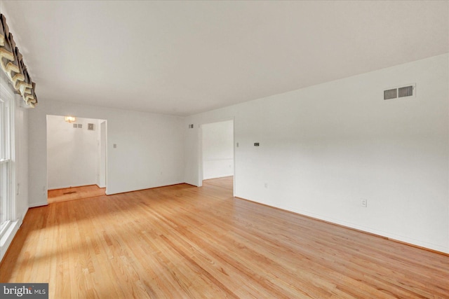 unfurnished room with light wood finished floors and visible vents