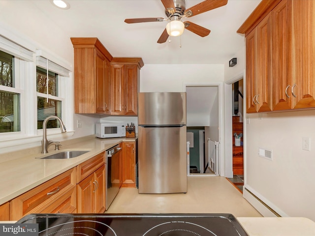 kitchen with brown cabinets, a sink, appliances with stainless steel finishes, and light countertops