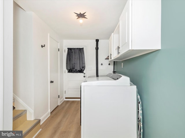 laundry area featuring light wood finished floors, cabinet space, independent washer and dryer, and baseboards