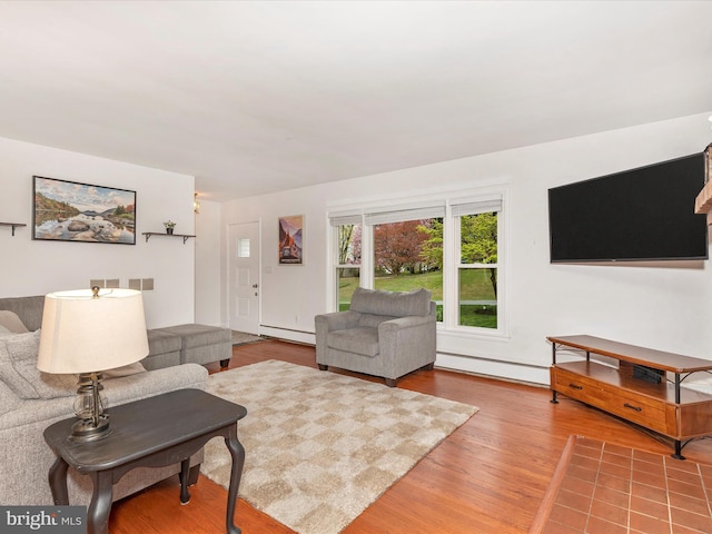 living area with wood finished floors, visible vents, and a baseboard heating unit