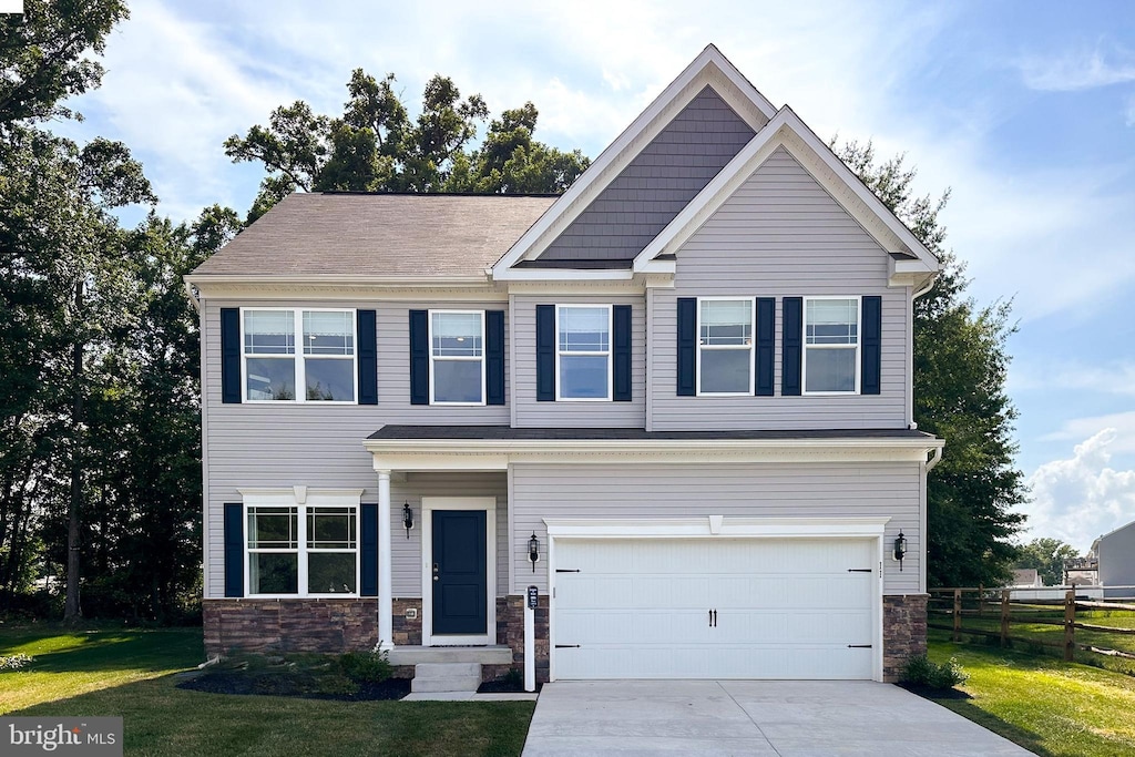 craftsman inspired home featuring a front lawn, stone siding, concrete driveway, fence, and an attached garage