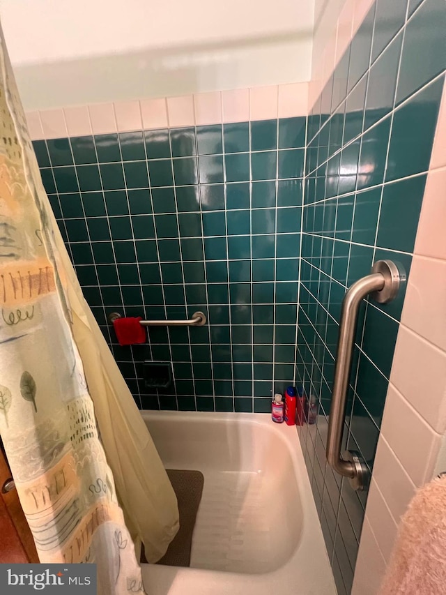 bathroom with a shower with curtain and a tub