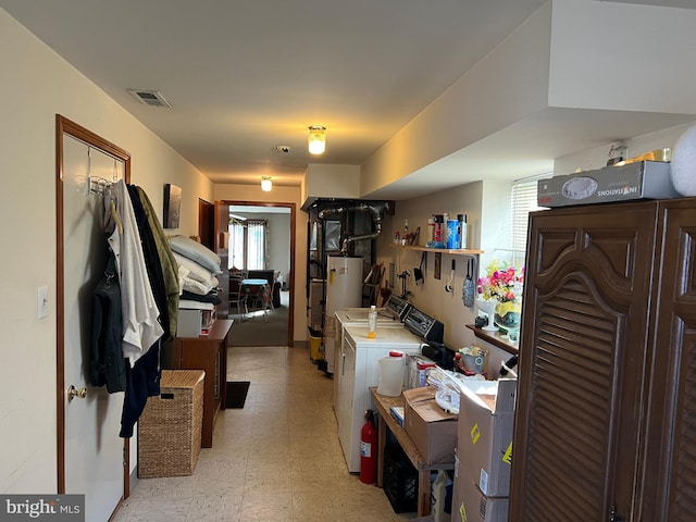 interior space featuring water heater, light floors, open shelves, light countertops, and visible vents