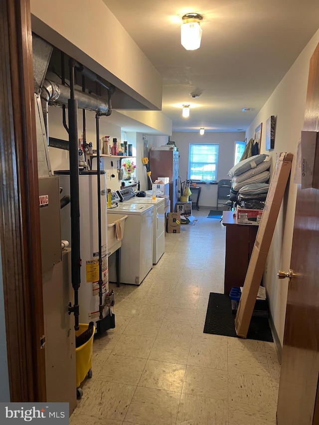 below grade area featuring light floors, water heater, and independent washer and dryer