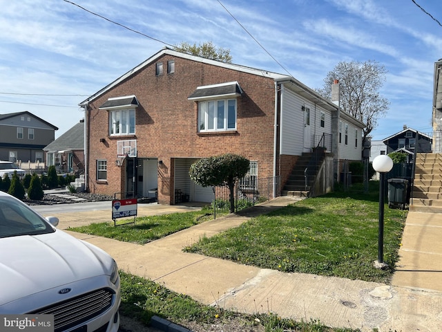 view of front of property featuring a front lawn and brick siding
