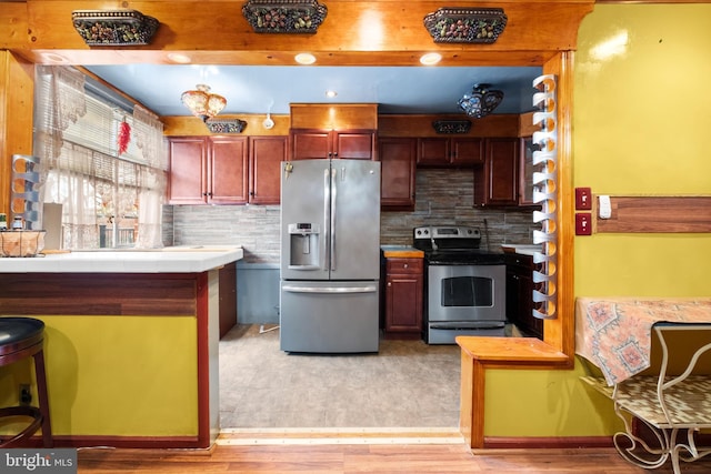 kitchen with tasteful backsplash, light wood finished floors, tile countertops, and stainless steel appliances