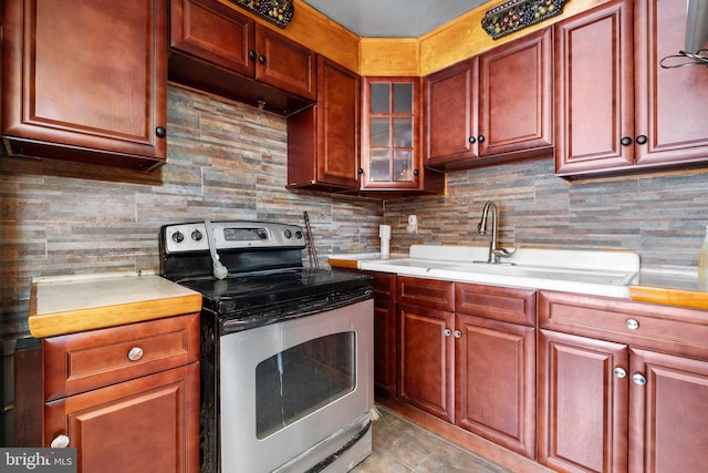 kitchen featuring stainless steel electric stove, light countertops, a sink, and tasteful backsplash