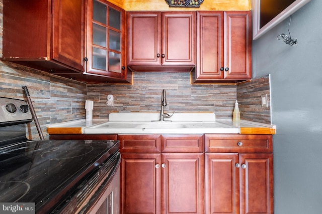 kitchen featuring electric range, decorative backsplash, dark brown cabinets, and light countertops